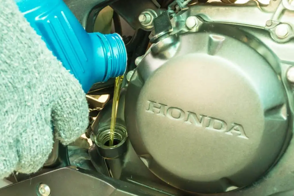 Close up of pouring new oil into honda engine