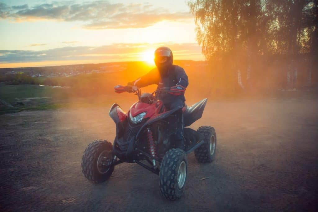 ATV Rider in the action on Honda sunset background